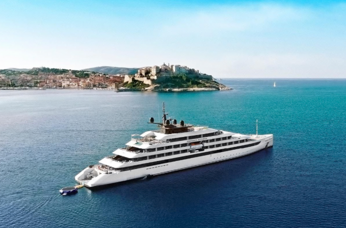 An Emerald Cruises luxury yacht sailing near a coastal town